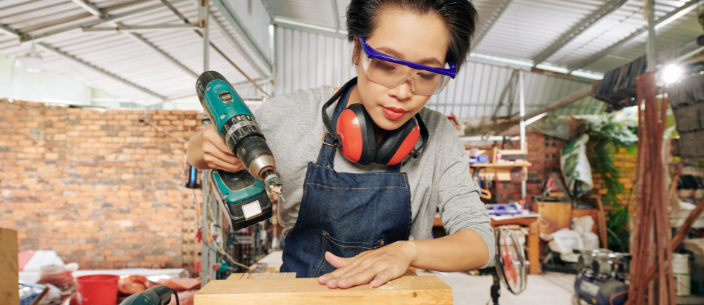 Malaysian using cordless wireless hand drill for drilling